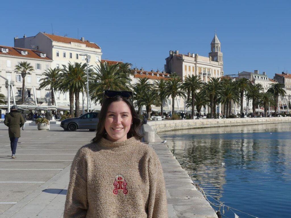 Tiani Travels standing on the Riva in Split, with the old town in the background