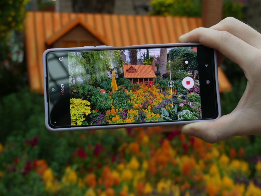a picture of a phone that is taking a video of the flowers in the Flower Dome